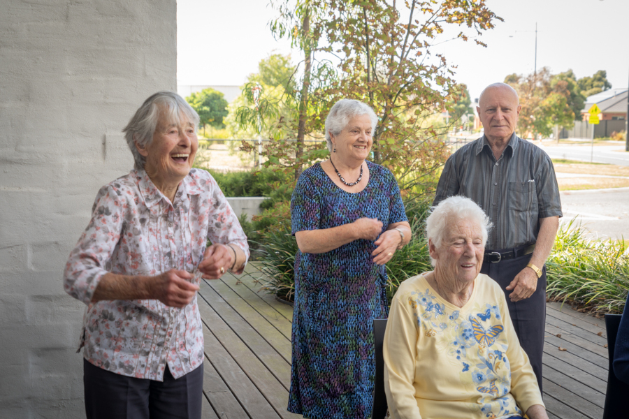 A group of older people laughing outside.